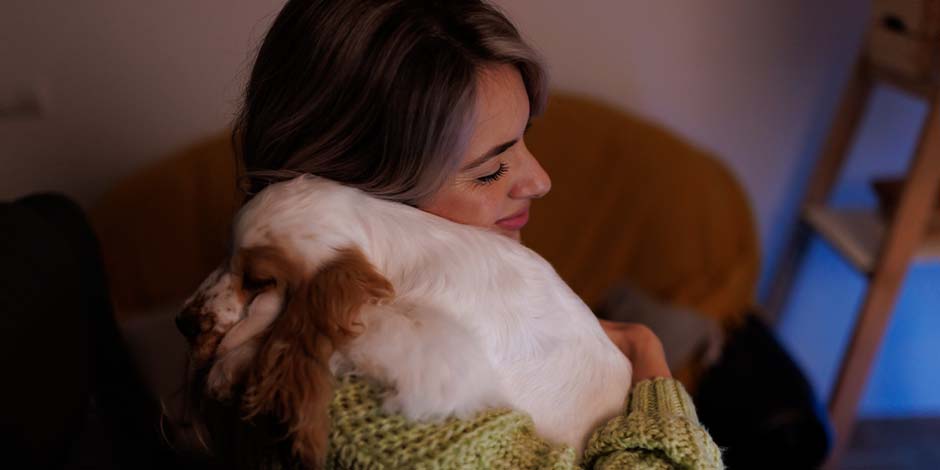 Tutora abrazando a su mascota. Aprende sobre la gastroenteritis en perros y prevén que el tuyo la presente.