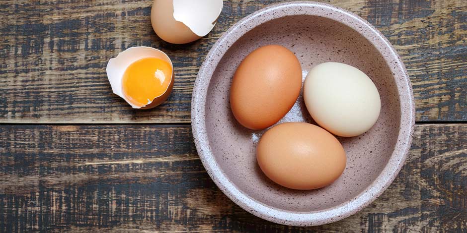 Los perros pueden comer huevo, pero no crudo. Evita dárselo sin cocinar. Huevos crudos en un recipiente.